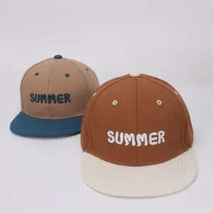 Dettaglio dei cappellini da bambino con visiera piatta e ricamo Summer in due varianti