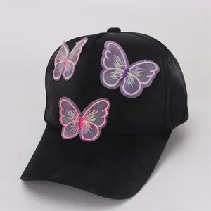 Close-up of embroidered butterfly patches with 3D organza wings on black baseball cap