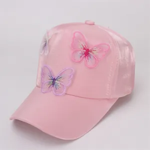 Detailed view of pink satin baseball cap with 3D butterfly embroidery and silky fabric
