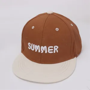Dettaglio del ricamo bianco SUMMER su un berretto da baseball in cotone bicolore