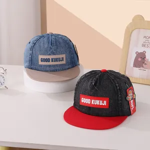 Detailweergave van denim baseballpetten met KUKUJI-patch voor kinderen en tieners