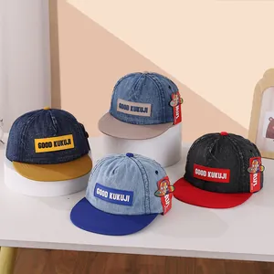 Detailweergave van vier kinderhonkbalpetten met KUKUJI-letterpatch en kleurblokken