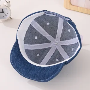 Dettaglio dell'interno di un cappellino in denim per neonati con fodera e cuciture a vista