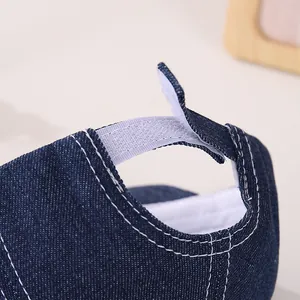 Détail de la patte velcro réglable et des surpiqûres sur la casquette en jean pour bébé