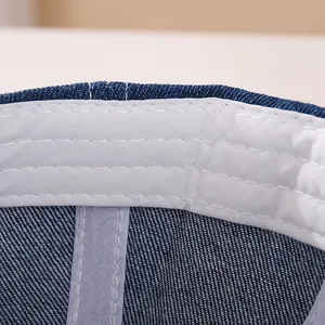 Dettaglio macro del cappello in denim per bambini con cuciture precise e fascia antisudore