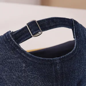 Detail van denim baseballpet achterzijde met metalen gesp en verstelbare riem