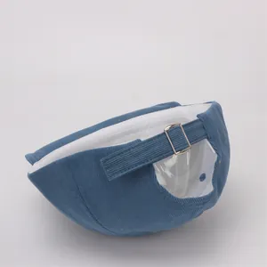 Detalle de gorra de pana azul para bebé con hebilla metálica ajustable en la parte trasera