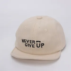 Detalle de textura de pana beige en gorra de béisbol con bordado frontal negro