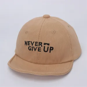 Detalle de gorra de pana para bebé en caqui con bordado NEVER GIVE UP y visera suave