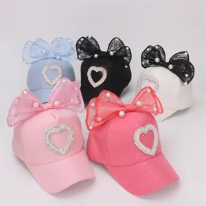 Detalle de gorras para niñas con lazos de encaje, perlas y corazones de diamantes