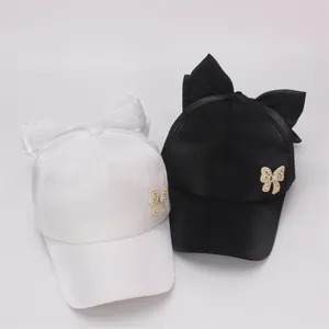 Detail of satin baseball caps with large bows and pearl beaded butterflies for girls