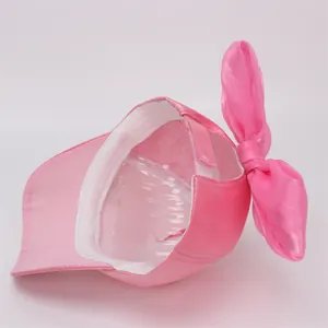 Detailed back view of pink satin girl's baseball cap with a large bow and velcro strap