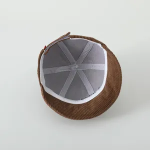 Détail interne du bonnet en velours côtelé marron avec doublure grise et bandeau blanc