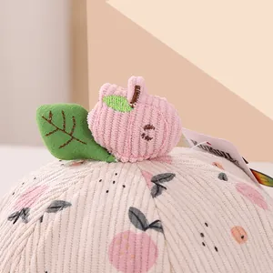 Detail of pink corduroy bucket hat with cute 3D apple leaf topper and apple prints