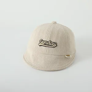 Détail de la casquette bébé en velours côtelé beige avec broderie Sunday et visière souple
