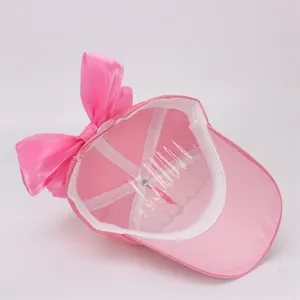 Detail of girls' pink baseball cap interior showing reinforced seams and satin bow