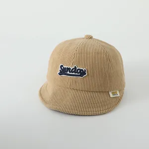Détail de la texture velours et broderie Sunday sur cette casquette bébé