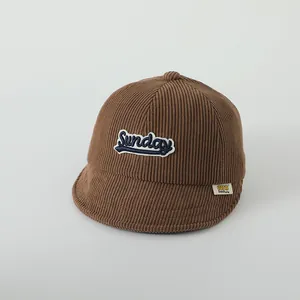 Détail de la casquette bébé en velours côtelé marron avec broderie Sunday et bord souple