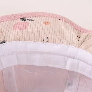 Close-up of baby bucket hat featuring corduroy peach print and soft pink fleece trim