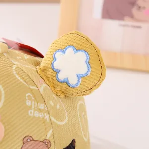 Detail of yellow corduroy baby cap featuring 3D bear ears and keep smile embroidery