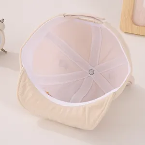 Detail of beige corduroy baby hat with breathable mesh lining and adjustable strap