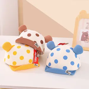 Detail of infant polka dot cotton hats with cute 3D ears in brown, yellow, and blue