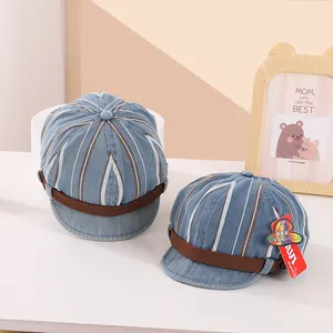 Détail de casquettes gavroche rayées en denim pour bébé avec sangle en cuir et bouton décoratif