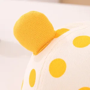 Macro shot of cotton knit baby hat with yellow polka dots and 3D ear detail