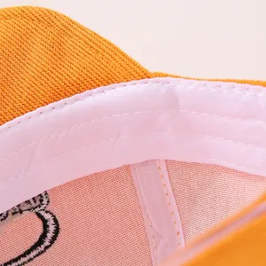 Detailed macro view of orange corduroy baby hat with soft pink mesh lining and sweatband