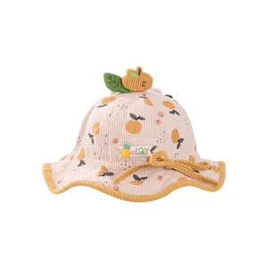 Pink corduroy baby bucket hat with orange fruit patterns and pumpkin top decoration