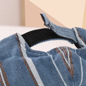 Détail de la casquette en denim pour bébé avec fermeture velcro et rayures marron