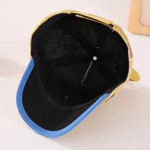 Detail view of the yellow corduroy baby cap showing internal black lining and stitching