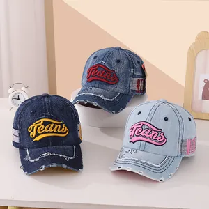 Détail de casquettes en denim pour enfants avec bords usés vintage et broderie Jeans