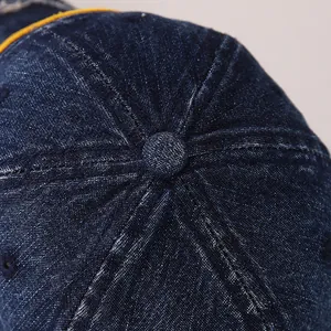 Vue détaillée du haut d'une casquette de baseball en denim bleu foncé à six pans cousus