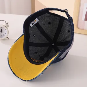 Détail de la casquette en denim avec visière contrastée, doublure et boucle métallique