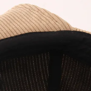 Detail view of khaki corduroy fabric texture and breathable inner mesh lining on infant cap