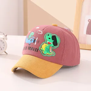 Dettaglio cappellino bimbo in velluto a coste rosa e giallo con ricamo dinosauro e testo