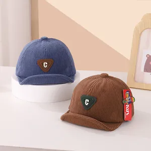 Detail view of corduroy baby baseball caps with C letter patch and soft short brims