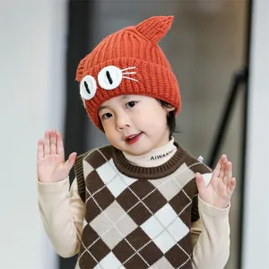 Detail of baby orange knit hat with cute 3D cat ears and cartoon eye embroidery