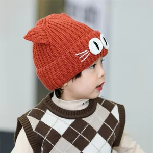Detail shot of orange knit baby hat with 3D cat ears and whiskers on a child model