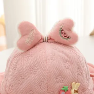 Dettaglio macro del cappello rosa per neonati con cuori 3D, fragola e tessuto morbido