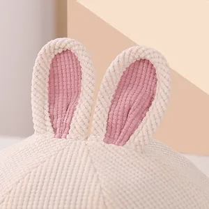 Detailed texture of white corduroy baby hat featuring cute pink rabbit ears design