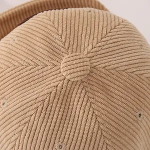 Close-up of beige corduroy baby baseball cap showing top button and six-panel stitching