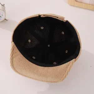 Detail view of the brown corduroy baby baseball cap interior showing black mesh lining