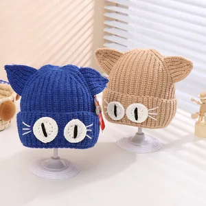 Detailed close-up of handmade knit baby beanies featuring cute cat ears and embroidery
