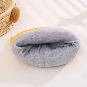 Detail view of the soft grey fleece lining and yellow knit texture of the baby winter hat