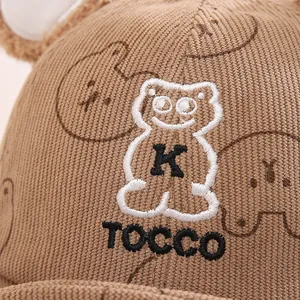 Dettaglio del cappello per neonati in velluto marrone con ricamo a forma di orso