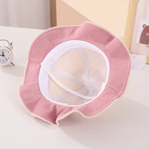 Pink corduroy kids bucket hat interior with white breathable lining and elastic chin strap
