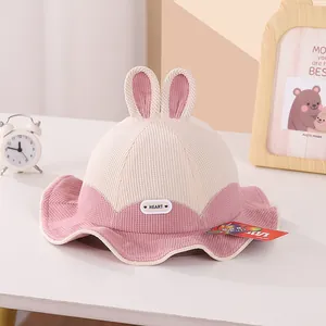 Detailed close-up of corduroy children's bucket hat with cute rabbit ears and heart label