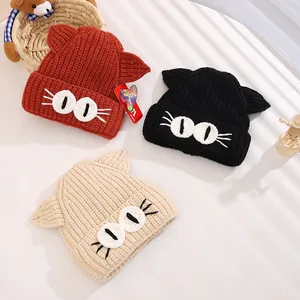 Detailed close-up of cute knitted baby hats with cat ears and embroidered cat eyes